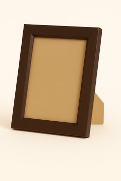 Portafoto color nogal fabricado en madera de pino finger, modelo 117-024. Marco de líneas limpias y acabado oscuro natural, ideal para fotografías o retratos. Su diseño sobrio y elegante combina perfectamente con estilos decorativos modernos, rústicos o minimalistas.