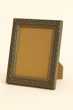 Portafoto barroco color plata, modelo 185-098. Marco decorativo de sobremesa fabricado en madera de pino finger, con relieve clásico tallado y acabado en película plateada satinada. Su diseño ornamental y elegante es ideal para enmarcar fotografías, retratos o láminas, aportando un estilo distinguido y atemporal a la decoración.