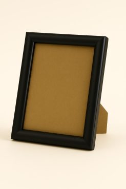 Portafoto color negro mate, modelo 196-053. Fabricado en madera de pino finger forrada en aluminio con acabado lacado mate. Su perfil redondeado y superficie satinada aportan un estilo elegante y contemporáneo, ideal para decorar espacios modernos, oficinas o ambientes minimalistas con fotografías o láminas.