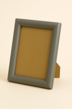 Portafoto color plata mate, modelo 196-098. Fabricado en madera de pino finger forrada en aluminio con acabado satinado. Su diseño redondeado y superficie lisa aportan una estética moderna y elegante, ideal para enmarcar fotografías, retratos o ilustraciones en espacios contemporáneos, minimalistas o profesionales.