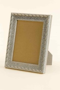 Portafoto de madera de ayous con acabado plata barroca, modelo 291-098. Moldura labrada con relieves florales y trenzados de estilo clásico, en un elegante tono plateado envejecido. Ideal para resaltar fotografías, retratos o ilustraciones con un toque sofisticado y decorativo.