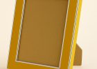 Portafoto de madera de pino finger color amarillo brillo con filos en plata, modelo 297-021. Diseño moderno y luminoso con acabado lacado brillante y borde plateado que realza fotografías, retratos o ilustraciones, aportando un estilo alegre y contemporáneo a la decoración.