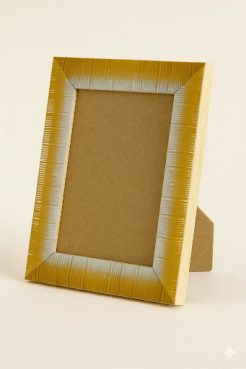 Portafoto de madera de ayous con acabado amarillo brillante y un fino filo color plata en el borde interior. Presenta un diseño con textura estriada vertical que aporta dinamismo y un efecto visual muy atractivo. Su estilo moderno y luminoso lo convierte en una pieza ideal para destacar fotografías en ambientes contemporáneos o espacios que busquen un toque de color elegante.